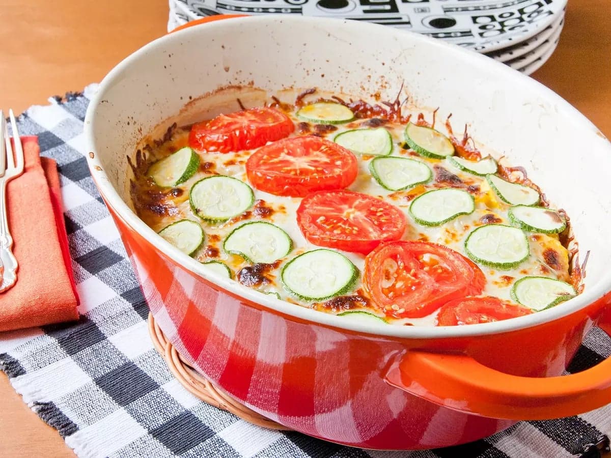 Đĩa gratin bí ngòi và cà chua xếp lớp, phủ phô mai vàng óng vừa ra lò